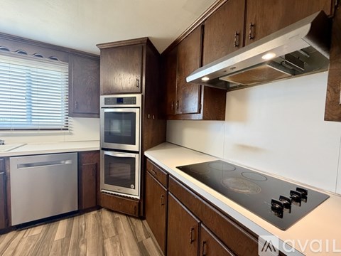A kitchen with wooden cabinets and stainless steel appliances.