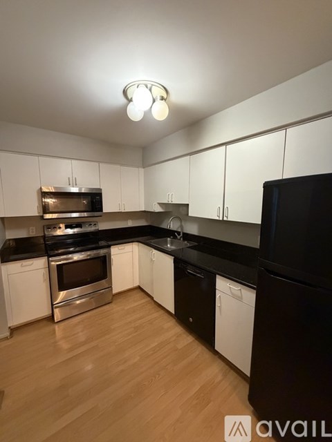 A kitchen with black countertops and white cabinets.