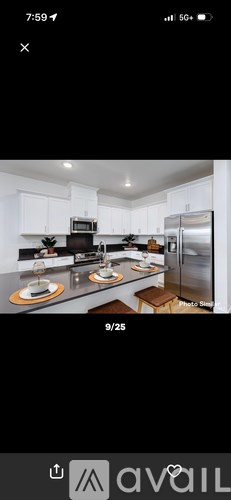 A modern kitchen with white cabinets and stainless steel appliances.