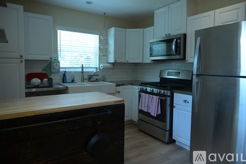 A kitchen with a wooden counter top and stainless steel appliances.