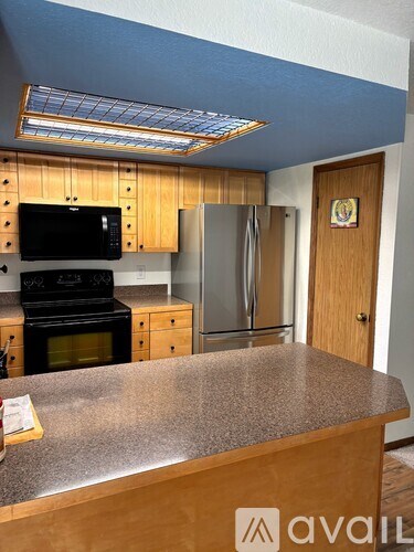 A kitchen with a stove top oven, microwave, and refrigerator.