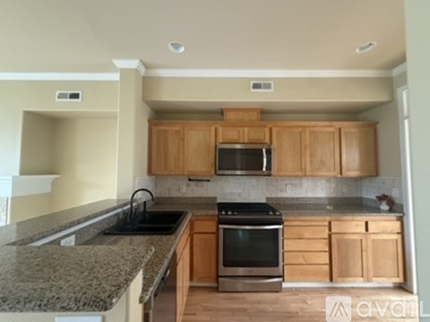 A kitchen with wooden cabinets and granite countertops.