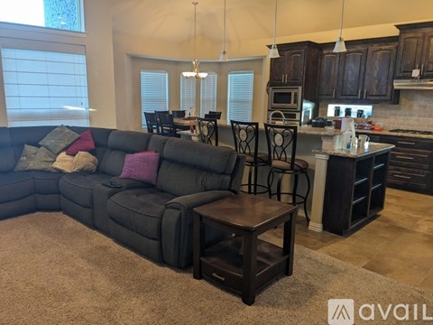 A living room with a black couch and a wooden coffee table.