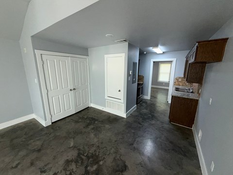 A room with a white door and a grey wall.