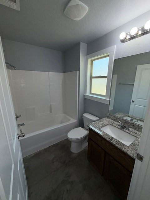 A bathroom with a toilet, sink, and bathtub.