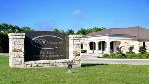 A stone sign with the words "C.V.R. Management Real Estate Investments & Management" on it.