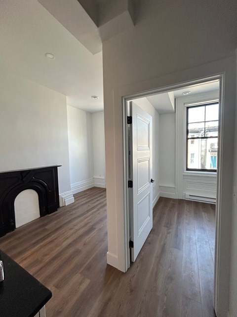 A room with a fireplace and wooden floors.