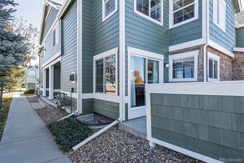 A row of houses with a sidewalk in front.