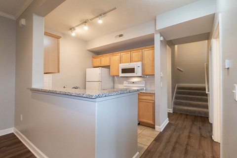 A kitchen with wooden cabinets and a white counter.