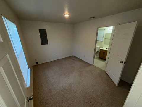 A room with a carpet floor and a speaker on the wall.