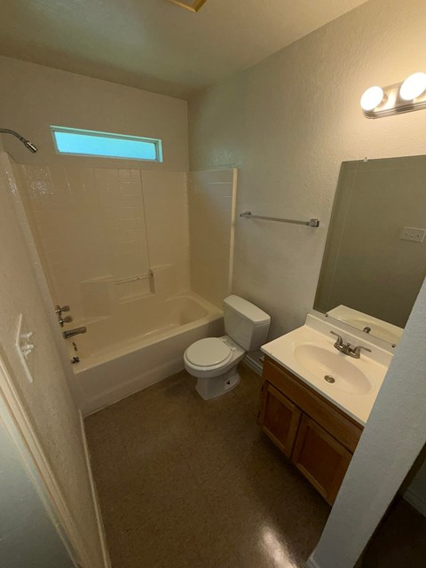 A bathroom with a toilet, sink, and bathtub.