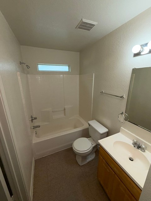 A small bathroom with a toilet, sink, and bathtub.