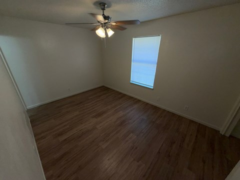 A room with a ceiling fan and a window.