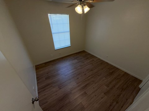 A room with a ceiling fan and a window.
