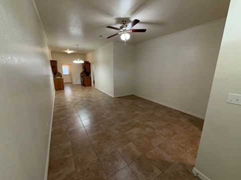 A room with a ceiling fan and tile flooring.