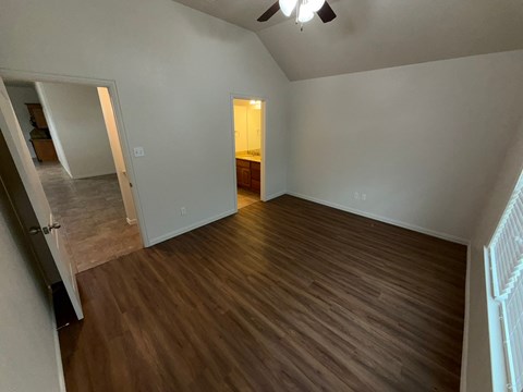 A room with wooden flooring and a ceiling fan.