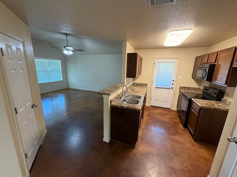 A kitchen with brown countertops and a white door.
