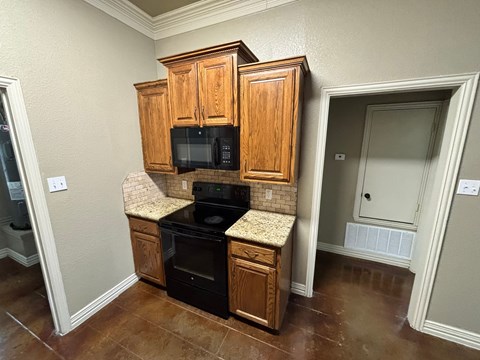 A kitchen with wooden cabinets and black appliances.