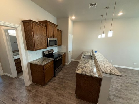 A kitchen with wooden cabinets and granite countertops.