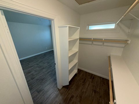 A small room with a window and a shelf.