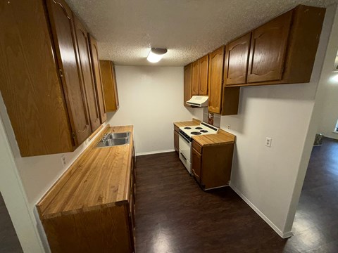 A kitchen with wooden cabinets and a wooden counter top.