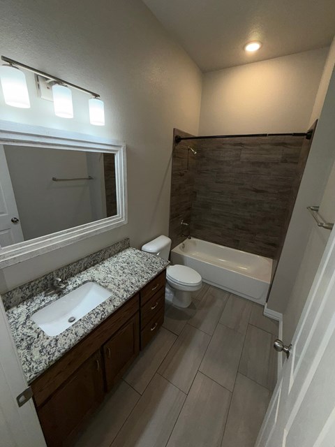 A bathroom with a sink, toilet, and bathtub.