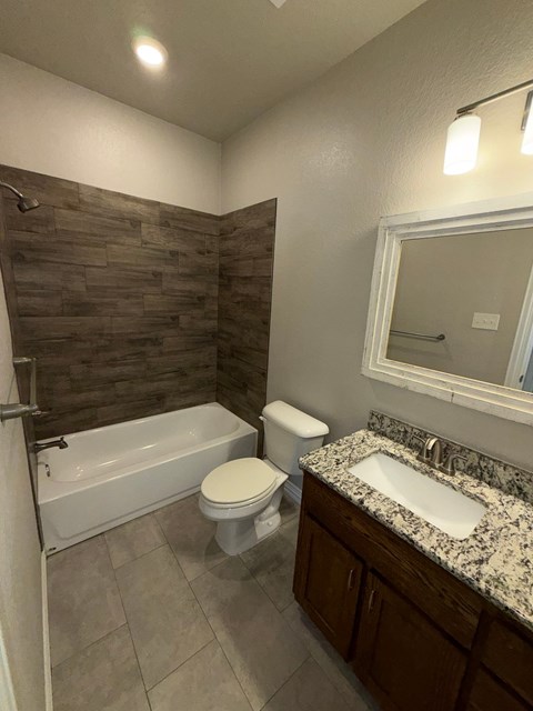 A bathroom with a wooden wall and a white bathtub.