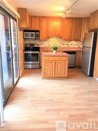 A kitchen with wooden cabinets and a wooden island in the middle.
