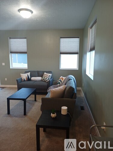A living room with a grey couch and a black coffee table.