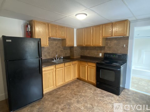 A kitchen with black appliances and wooden cabinets.
