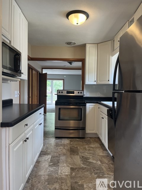 A kitchen with white cabinets and a black countertop.