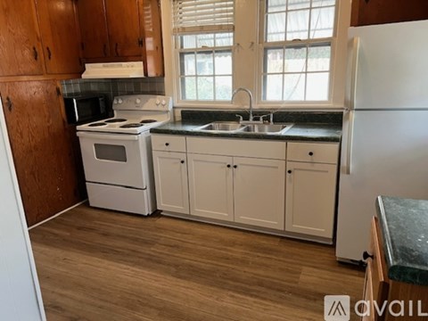 A kitchen with white appliances and wooden cabinets.