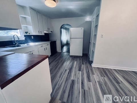 A kitchen with white cabinets and a white refrigerator.
