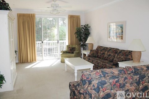 A living room with a couch, chair, and a table with a plant on it.