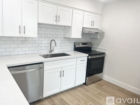 A kitchen with white cabinets and a black oven.
