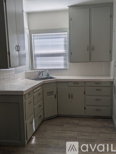 A kitchen with white cabinets and a marble countertop.