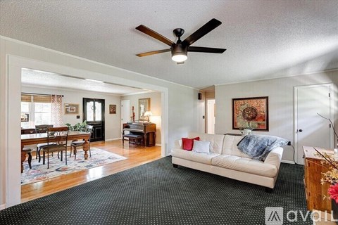 A living room with a white couch and a ceiling fan.