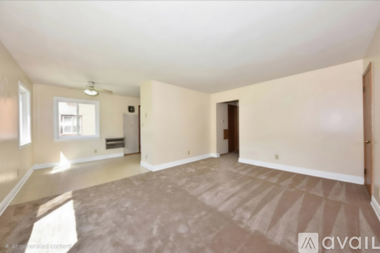 A spacious empty room with a carpeted floor and a window.