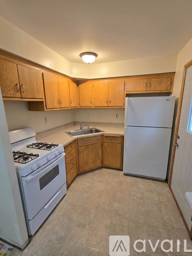 A kitchen with wooden cabinets and a white refrigerator.