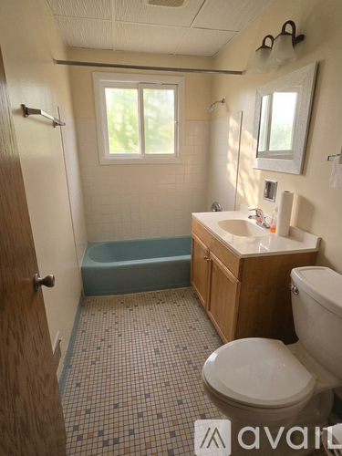 A bathroom with a toilet, sink, and bathtub.