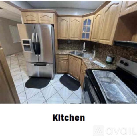 A kitchen with wooden cabinets and a stainless steel refrigerator.