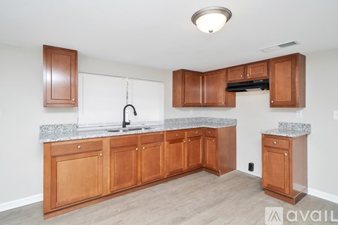 A kitchen with wooden cabinets and a granite countertop.