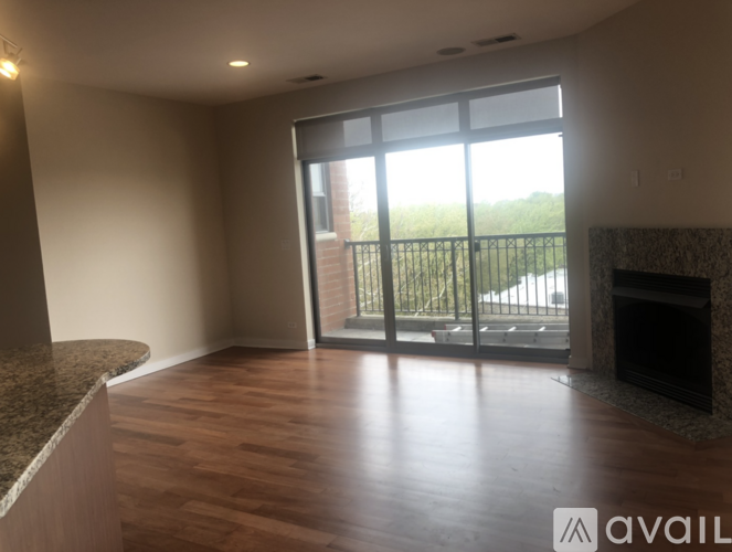 A spacious living room with a fireplace and sliding glass doors leading to a balcony.