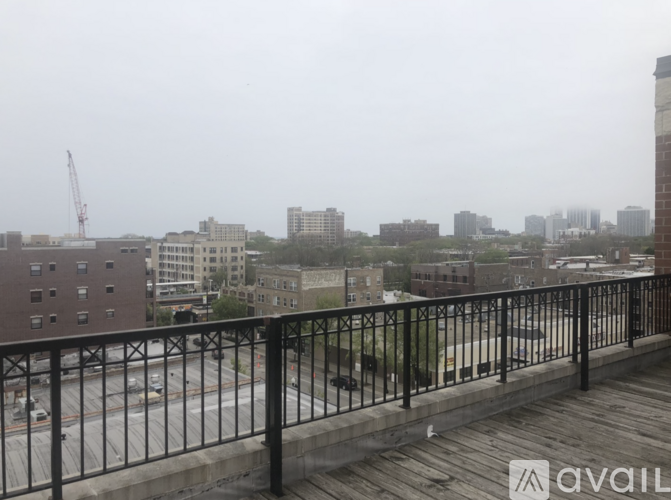 A rainy day in the city with a view of the buildings and a construction crane.