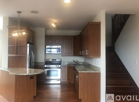 A kitchen with wooden cabinets and a stainless steel refrigerator.