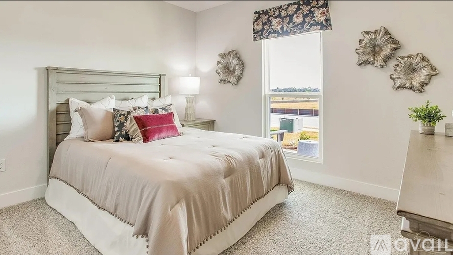 A bedroom with a large bed and a window with a view of the outside.