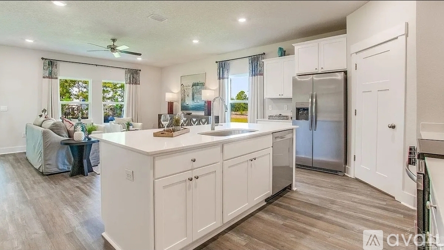 A kitchen with white cabinets and a refrigerator.