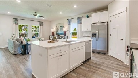 A kitchen with white cabinets and a refrigerator.