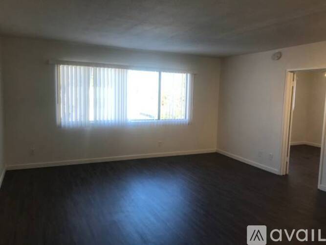 A room with a window and wooden flooring is available for rent.