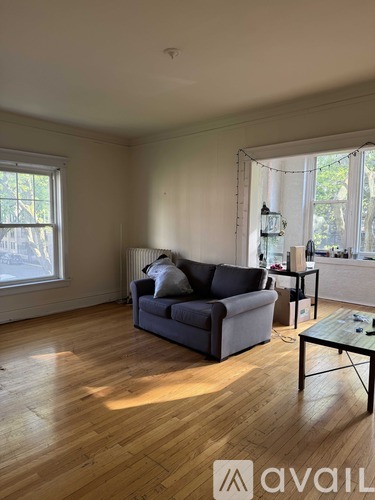 A living room with a grey couch and wooden floors.